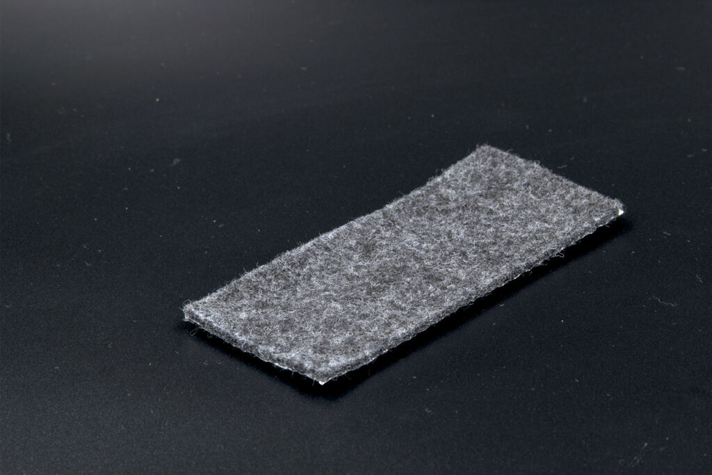 Spód z szarego, zbitego filcu w laminacie metalicznym.